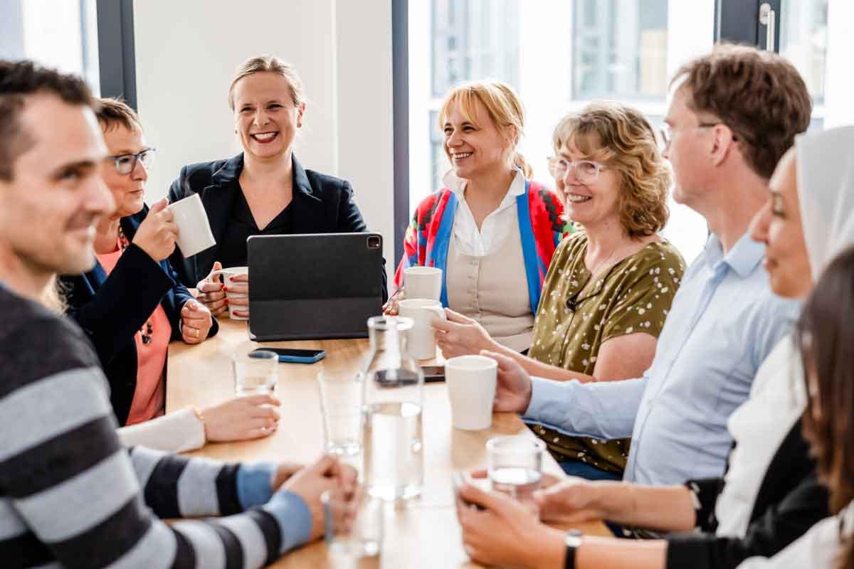 Fotos von Mitarbeitern am gemeinsamen Tisch